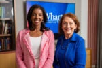 Dean Erika James standing with professor Olivia Mitchell